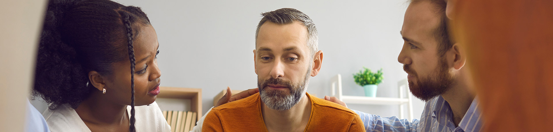 two people facing a bearded man in the center